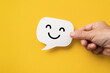 © Ratana21 - Hand hold happy face on real speech bubbles to each other. Giving good words to each other or giving positive feedback satisfaction from good customer feedback reviews