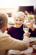 © peopleimages.com - Senior couple, dinner and cheers or toast in home for anniversary, date or retirement with love in marriage. Elderly, people and eating together with wine and happy for romance and relationship