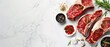 Three raw beef steaks with spices and herbs on white marble background.