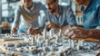 © ontsunan - A group of young professionals around a table, fitting together a 3D puzzle model of a city, in a realistic office setting