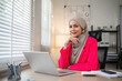© wichayada - Young Muslim businesswoman wearing hijab sits working with laptop managing personal business in private office.