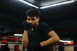 © dsheremeta - A boxer with bandages on his fists is ready for a fight. Sporty young man in boxing club, looking at camera.