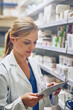 © peopleimages.com - Pharmacy, woman or pharmacist with tablet for research or checking medical prescription on shelf. Internship, healthcare or doctor reading online checklist in clinic for drugstore inventory storage