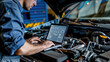 © Александр Довянский - a mechanic with a laptop on a car engine conducts computer diagnostics of a car in a car service center