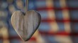 Wooden heart hanging in front of blurred American flag background