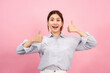 © Katcha - Young asian woman using both hands with fingers to thumbs up gesture with surprised and excited face