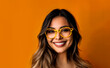 © Mario - smiling woman wearing yellow glasses located on orange background