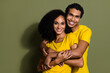 Portrait of two nice people embrace empty space wear t-shirt isolated on khaki color background