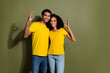 Portrait of two nice people demonstrate okey symbol empty space wear t-shirt isolated on khaki color background