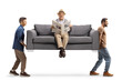 © Ljupco Smokovski - Young men carrying a gray sofa with an elderly man sitting and reading a newspaper