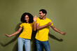 Portrait of two nice people rejoice dancing wear t-shirt isolated on khaki color background