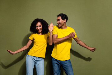 Wall Mural - Portrait of two nice people rejoice dancing wear t-shirt isolated on khaki color background