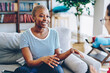 © BullRun - Cheerful african american woman talking with female friend spending time together at apartment, multiracial hipster girls having conversation at home interior, female explaining emotional gesture
