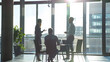 © Generative AI - Diverse millennial business team talking in meeting room negotiating on project at table at glass wall panoramic window discussing deal in open space modern office interior Wide shot : Generative AI