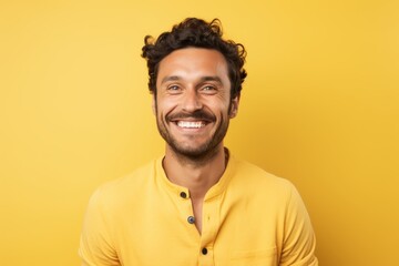 Wall Mural - Portrait of a grinning man in his 30s smiling at the camera in front of soft yellow background