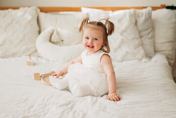 Wall Mural - Cute adorable baby girl in white dress indoors closeup portrait Happy childhood funny kid