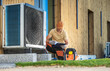 © Tomasz Zajda - Worker Installing or Fixing Modern Heat Pump