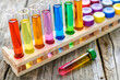 Vibrant laboratory test tubes with colorful chemicals on wooden surface