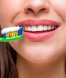 © Yevhen - Closeup on happy woman brushing teeth. Woman brushing cleaning teeth. Girl with toothbrush. Oral hygiene. Smiling woman with healthy beautiful teeth holding a toothbrush