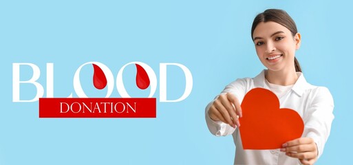 Wall Mural - Banner for World Blood Donor Day with young female doctor holding paper heart