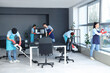 © Pixel-Shot - Team of young janitors cleaning in office