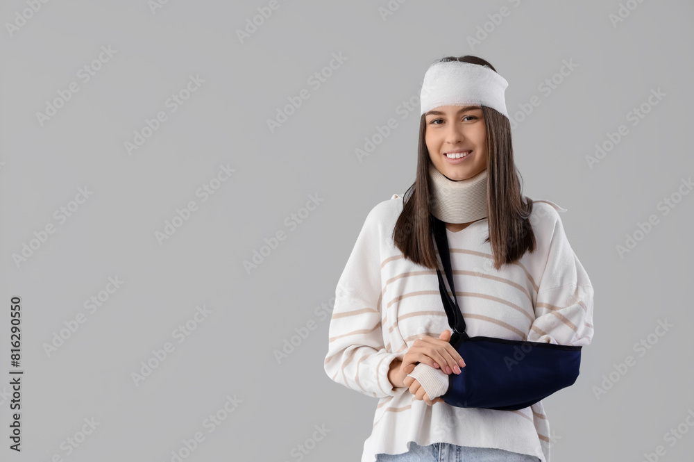 Injured young woman after accident with broken arm on light background