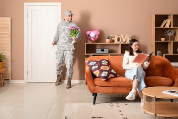 Wall Mural - Man in military uniform with bouquet of flowers sneaking to surprise his wife at home. Valentine's Day celebration