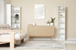 © Pixel-Shot - Wooden chest of drawers, shelving unit and comfortable sofa in interior of modern living room