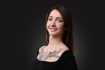 Poster - Portrait of smiling tattooed woman on black background