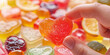 a hand holding a heart shaped gummy candy, generative AI
