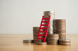 © pla2na - Red ladder and stack coin on wooden table with white wall background copy space. Money management planning, business strategy for growth profit step by step. Business, financial and investment concept