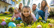 © Kien - A young girl wearing bunny ears and a blue outfit is playing on the lawn with her family, with Easter eggs scattered around them