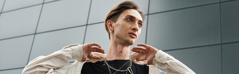 Wall Mural - A young queer individual, dressed stylishly, strikes a pose in front of a building, exuding confidence and pride.