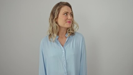 Poster - Thoughtful young blonde woman in shirt, smiling and looking away, standing sideways over white isolated background