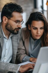 Poster - A man and a woman looking at a laptop. Suitable for technology concepts