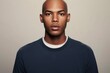 © alisaaa - studio portrait on white background of young african american man with shaven head and dark blue shirt
