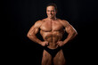 © Michael Shifrin - Athlete bodybuilder posing for a sports magazine in the studio on a black background. Grain effect used
