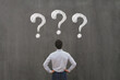 © Song_about_summer - business man looking at questions on chalkboard, ask questions, FAQ concept, uncertainty, interrogation marks