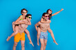 © deagreez - Photo of funky excited buddies company dressed bikini holding hands arms having fun empty space isolated blue color background