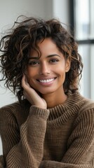 Wall Mural - A happy African American woman with curly hair wearing a brown sweater smiles warmly at the camera