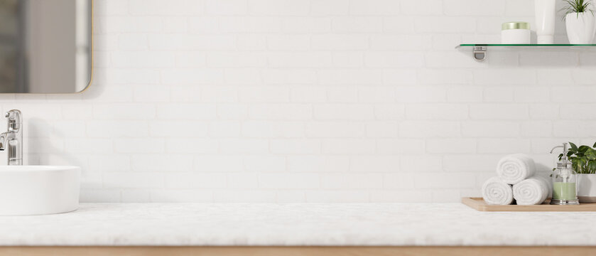 A modern, luxurious white bathroom countertop features a sink, a mirror, a toiletry set.