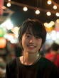 © おでんじん - 夜の街で輝く若いアジア人男性の魅力的な笑顔
