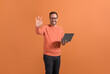 © Moon Safari - Cheerful handsome freelancer with laptop computer showing OK sign confidently on orange background