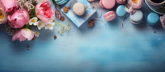 Aufkleber - A top view of a table with a blue color where there are perfume flowers macarons and boxes creating a visually appealing copy space image