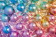 © ALL YOU NEED studio - background of shiny, reflective pastel colorful Christmas balls ,ornaments on pastel rainbow crumpled foil, creating an elegant and festive texture