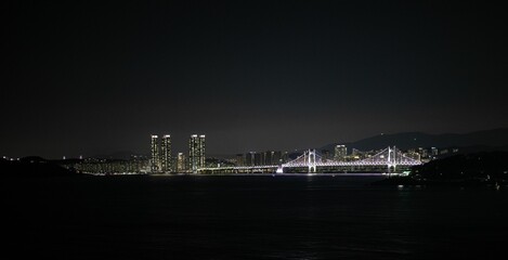 Wall Mural - Breathtaking view of a picturesque bridge illuminated at night in the city of Busan, South Korea