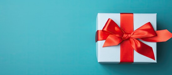Aufkleber - Top view of a gift box with a red bow on a blue background serving as a holiday background Perfect for copy space image