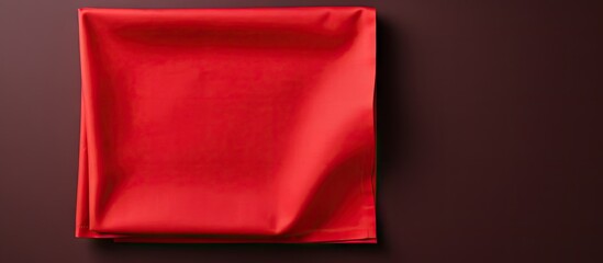 Poster - The red kitchen napkin is placed on a table viewed from the top The folded cloth is isolated and ready for use in a mockup Flat lay photography is used for a minimalist aesthetic Copy space is availab