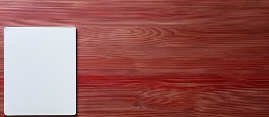 Aufkleber - Red notebook and white tablet on a table with a wooden texture. copy space available