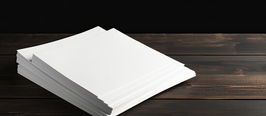 Poster - A mock up of blank paper sheets for a brochure is stacked on a black wooden background creating a copy space image